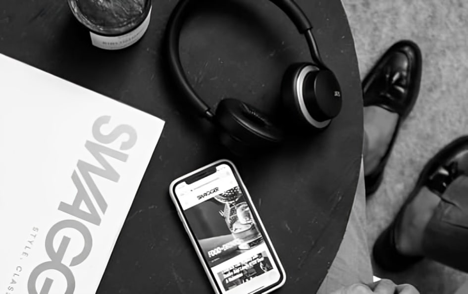 A XX99 Mark II Black Headphones in the table beside Phones and magazine.